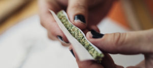 woman rolling a joint of marijuana in El Paso County