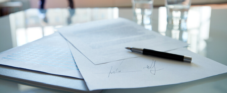 Signed contract resting on top of a glass table