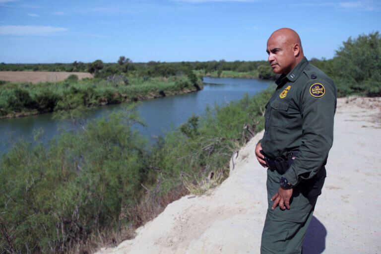 Roma, Texas, USA - September 21, 2015: A Border Patrol agent looks across the Rio Grande River towards the Mexican town of Miguel Aleman. This stretch of the river is notorious for being used to ship drugs, primarily marijuana, to the United States.